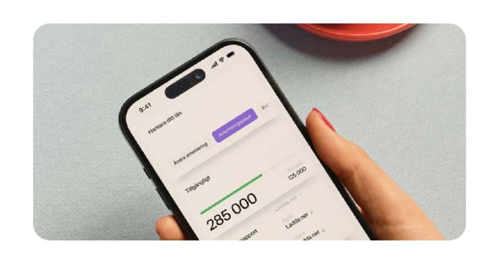 Hand holding a phone showing an available loan amount of 285 000